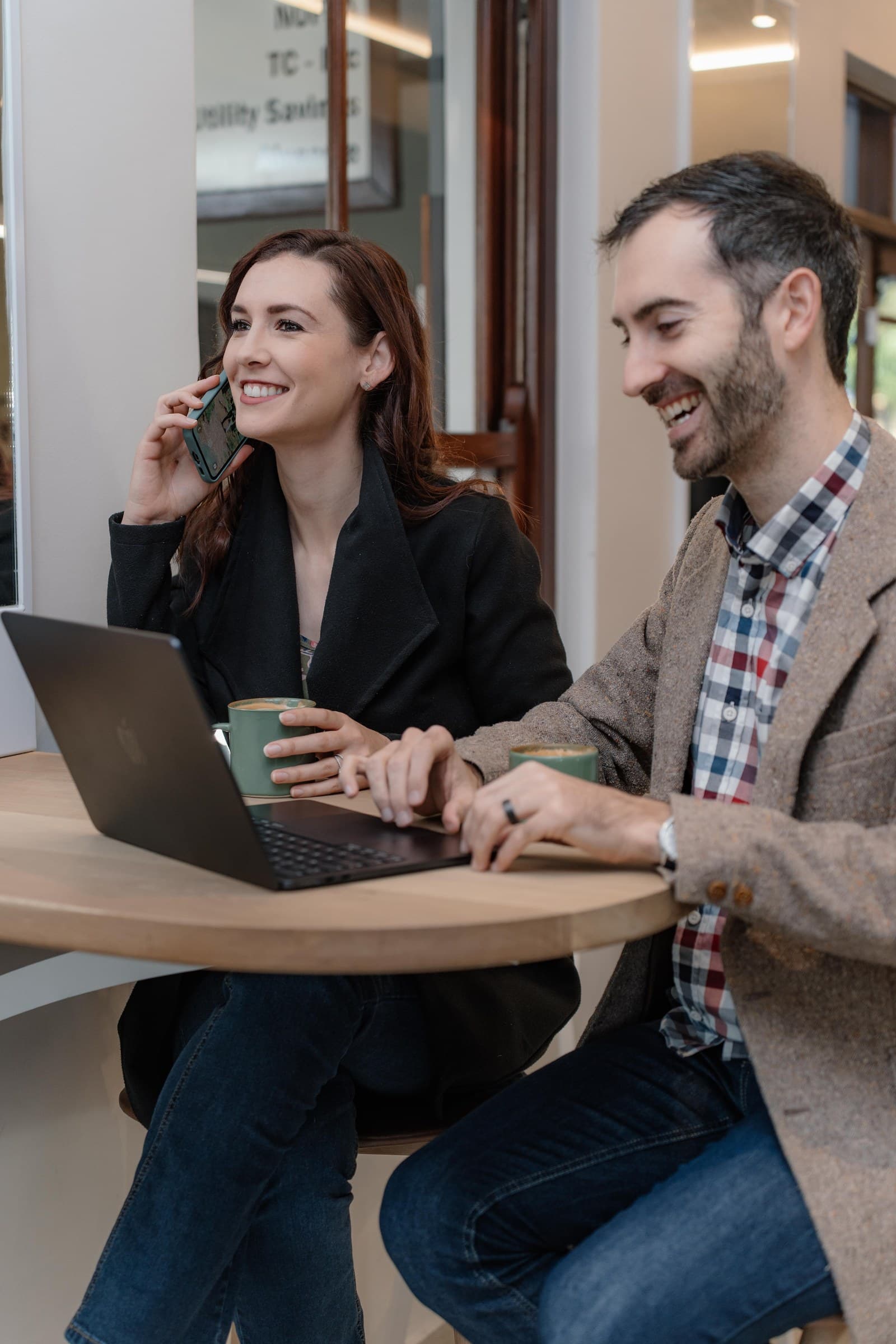 Two colleagues on a call and working from a laptop, ready to hear about your project